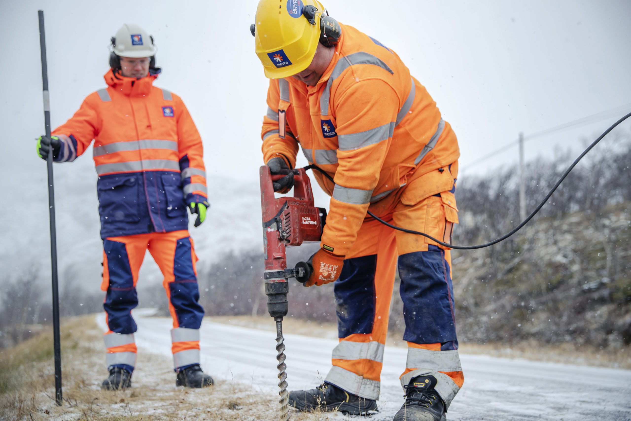 To menn som setter ned brøytestikker